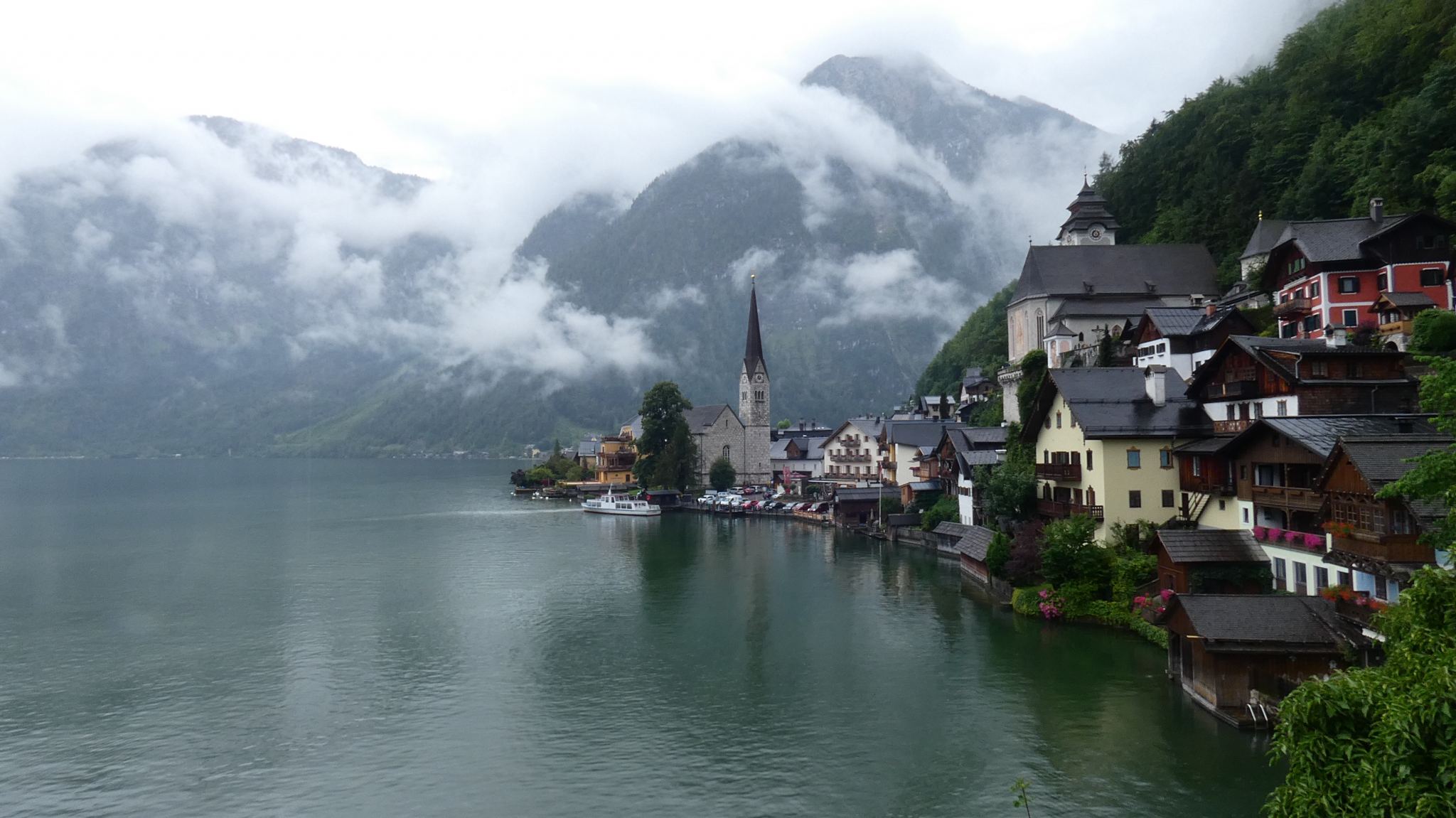 hallstatt view towards the church over the lake with mountains in the background